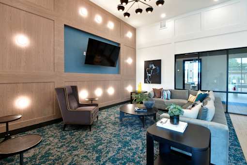A TV mounted on a beautiful wood accent wall surrounded by modern furniture