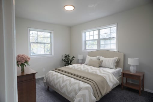 a bedroom with a bed and two windows  at Venue at Carrollton, Georgia