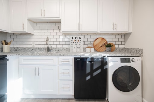 a white kitchen with white cabinets and a washing machine  at Venue at Carrollton, Georgia