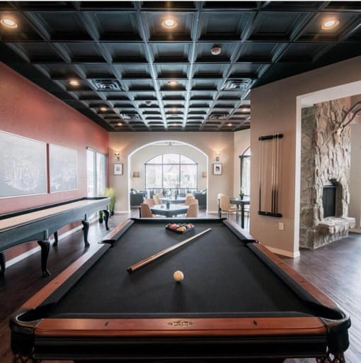 a pool table in a living room with a large window at The Villa at River Pointe, Maumelle, Arkansas