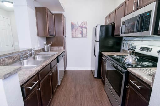 a kitchen with stainless steel appliances and marble counter tops at The Villa at River Pointe, Maumelle