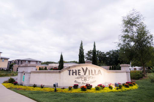 the villa entrance sign with flowers and grass at The Villa at River Pointe, Maumelle, Arkansas