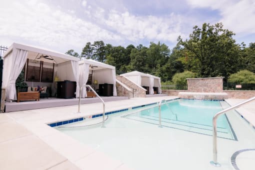 a swimming pool in front of a house with a pool at The Villa at River Pointe, Maumelle