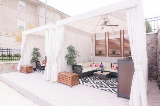 a patio with a white canopy and a living room with white curtains at The Villa at River Pointe, Arkansas, 72213