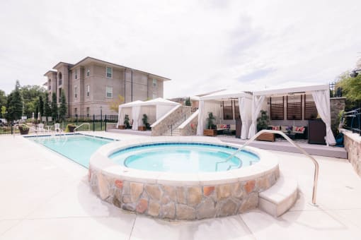 our apartments have a large pool and spa with umbrellas at The Villa at River Pointe, Maumelle, Arkansas