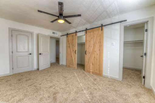 A room with a ceiling fan and sliding doors.at The Garden District Apartments, Germantown, 38138  
