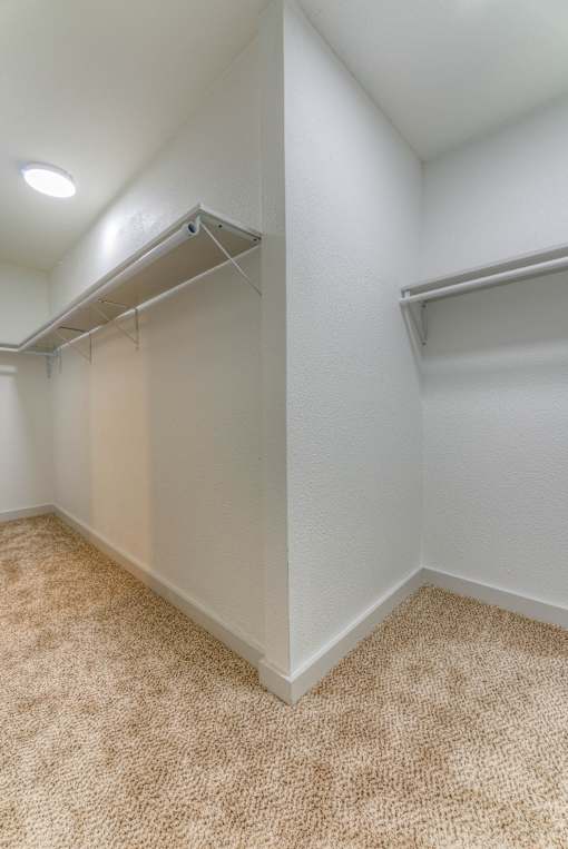 A white room with a carpeted floor and a white wall.at The Garden District Apartments, Germantown, TN  