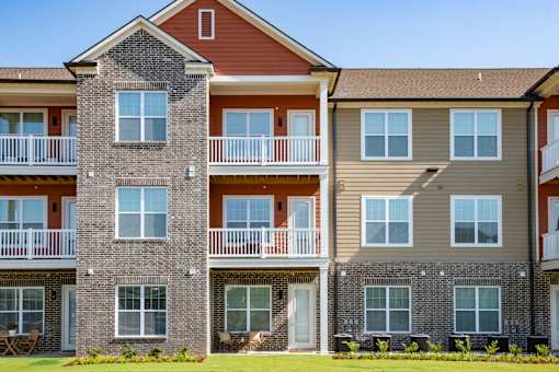 A multi-story apartment building with balconies and windows. at Grays Creek Apartments, Cordova, TN, 38018