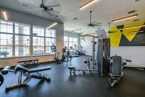 A gym with a variety of equipment including treadmills, weights, and exercise machines. at Grays Creek Apartments, Cordova