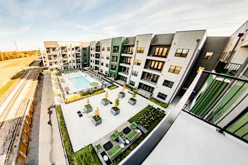 A modern apartment complex with a pool and landscaped courtyard at Harbor Side at Conwood Flats Apartments, Memphis