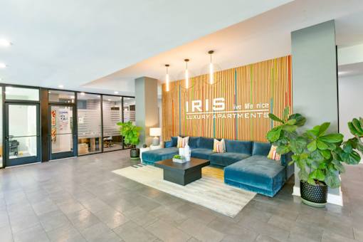 A modern living room with a blue couch and a sign that says "IRIS LUXURY APARTMENT".
