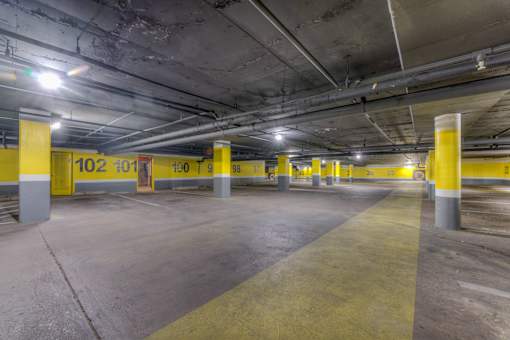 A parking garage with yellow poles and concrete floors.at Iris Luxury Apartments, Memphis  