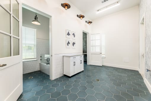a bathroom with white walls and a black and white tile floor at The Livano Kemah, Kemah, TX, 77565