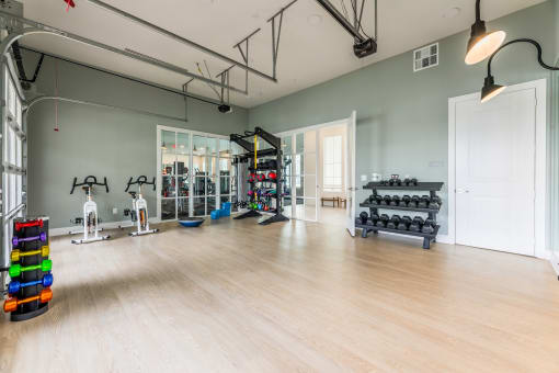 a spacious fitness room with hardwood floors and a wall of windows at The Livano Kemah, Kemah, 77565