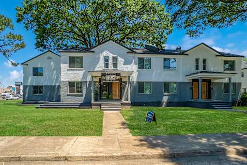 A two-story house with a front yard and a tree at Kiwi Goji Apartments, TN, 38111