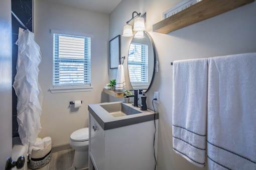 a bathroom with circle mirror at Kiwi Goji Apartments, TN, 38111