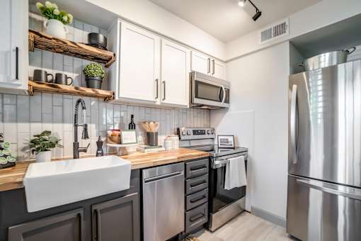a kitchen with modern gray and white cabinets at Kiwi Goji Apartments, Memphis, Tennessee