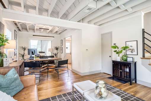 A living room with a couch, a table, and a staircase at Kiwi Goji Apartments, Memphis, 38111