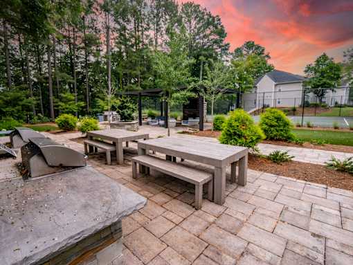 A backyard with a picnic table and benches. at Manchester at Mansell, Roswell, 30076 