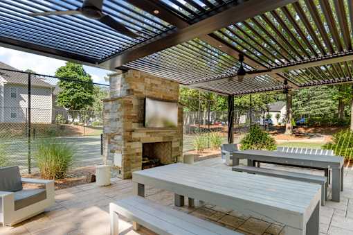 A patio with a fireplace and seating area. at Manchester at Mansell, Roswell, GA