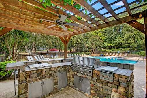 A patio with a grill and a pool table. at Mill House at East Cobb, Marietta, GA 30067 