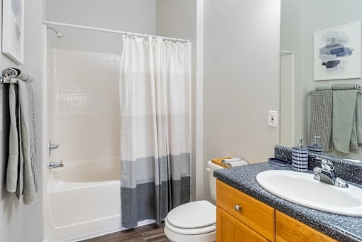 A bathroom with a white tub, toilet, and sink.