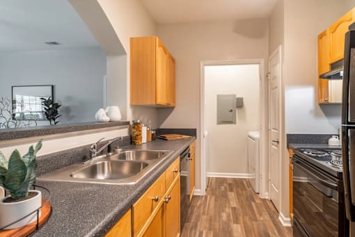 A kitchen with wooden cabinets and a stainless steel sink.