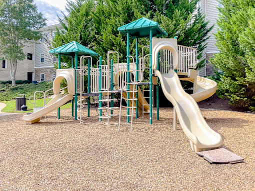 A playground with a green roof and a yellow slide.