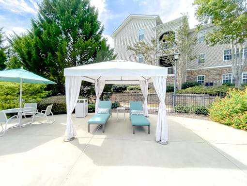 A white canopy is set up over a table and chairs.