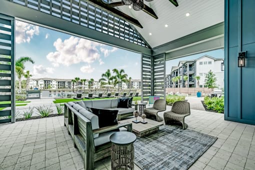 a covered patio with couches chairs and a coffee table at Livano Nature Coast, Spring Hill, FL