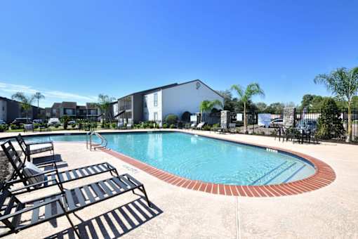 Pool surrounded by sun loungers at Normandy Woods in Riviera East, Houston, TX, 77015