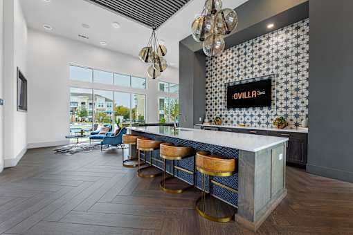 A bar area with a white counter and blue stools.