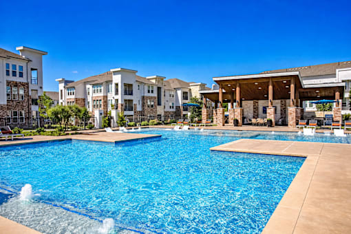 A large swimming pool with a fountain in the middle of it.