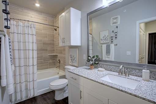 A bathroom with a white toilet, sink, and shower curtain.