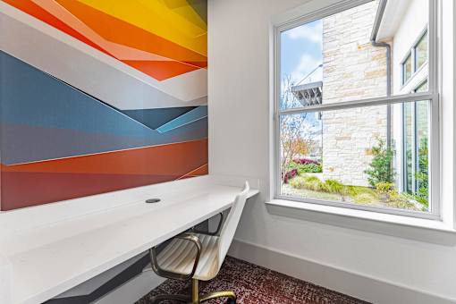 A room with a white desk and a chair.