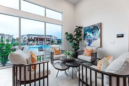 A living room with a view of a pool and buildings outside the window.