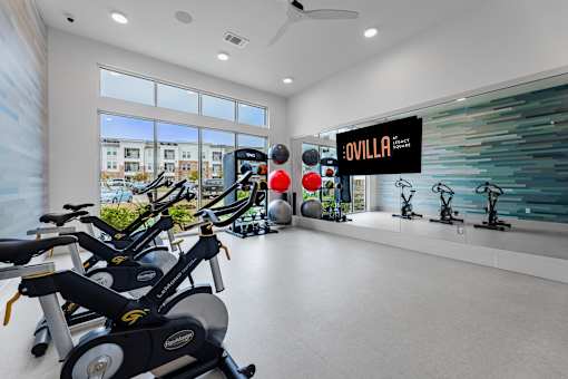A gym with exercise equipment and a sign that says "Ovilla".