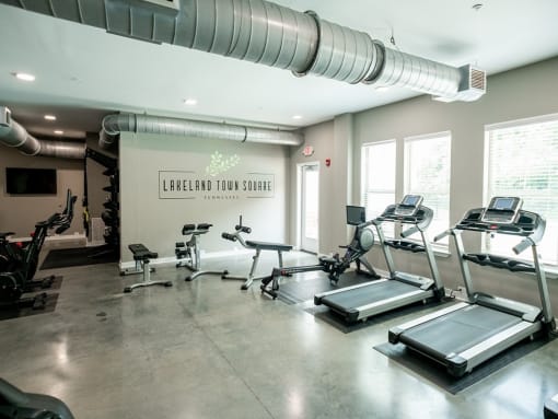 a row of cardio machines in a gym at Lakeland Town Square Apartments, Lakeland, TN