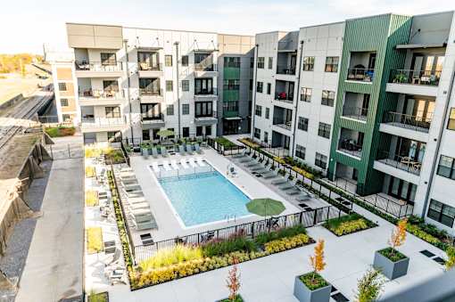A swimming pool is surrounded by apartment buildings at Harbor Side at Conwood Flats Apartments, Memphis, TN, 38107