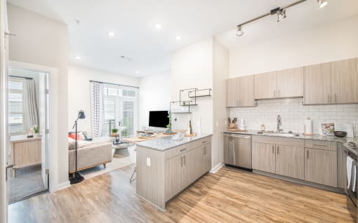 a kitchen and living room with wood floors and white walls at The Baxly, Savannah, GA, Georgia , 31401