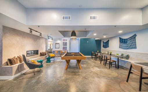 a game room with a pool table and tables and chairs at The Baxly, Savannah