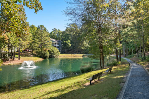 Onsite lake with water fountain and walking trail  located at St. Andrews Apartments in Johns Creek, GA 30022