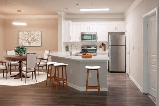 A kitchen with a table and chairs and a fridge.