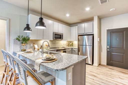 a kitchen with a marble counter top and a stainless steel refrigerator at The Beck at Hidden River, Florida