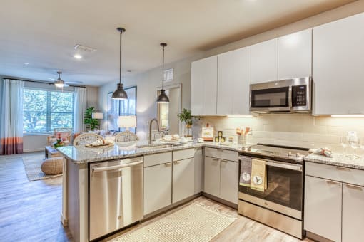 a kitchen with stainless steel appliances and granite counter tops at The Beck at Hidden River, Tampa