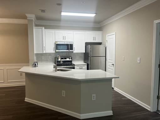 a kitchen with white cabinets and a white counter top at The Berkeley Apartments, Georgia, 30096