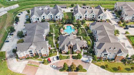 A bird's eye view of a residential area with houses and a swimming pool at The Fenwick Apartments, Humble, TX