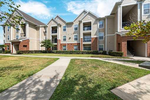 Apartment complex with a walkway in front at The Fenwick Apartments, Humble, 77396