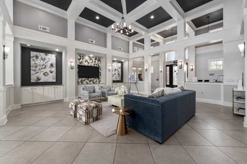 A spacious living room with a large blue sofa and a patterned rug at The Fenwick Apartments, Texas