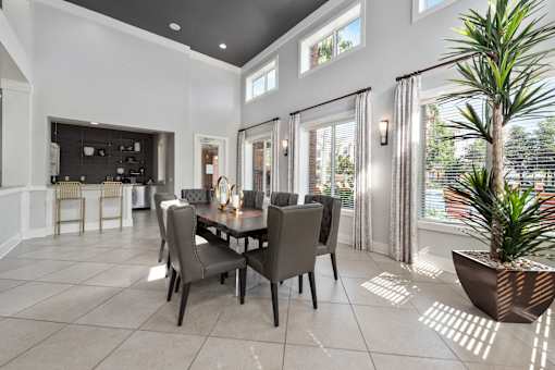 A dining room with a table set for six with a plant in a pot on the floor at The Fenwick Apartments, Humble, 77396
